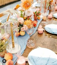 the table is set with plates, glasses and flowers