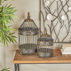 two bird cages sitting on top of a wooden table