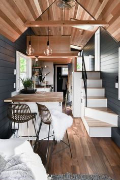 the interior of a tiny house with wood and white accents, including stairs leading up to an open floor plan