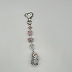 a keychain with a bear and heart charms attached to it's side