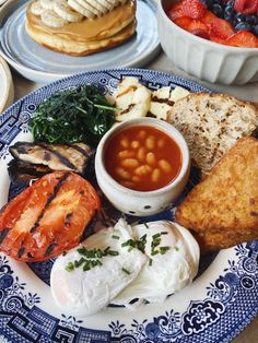 a blue and white plate topped with different types of food on top of a table