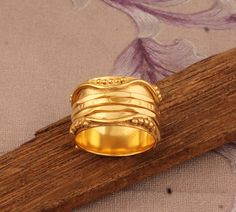 a gold ring sitting on top of a wooden stick