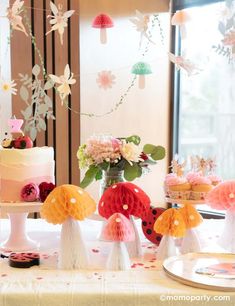 a table topped with lots of cakes and cupcakes