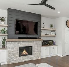 a living room filled with furniture and a flat screen tv mounted on a wall above a fire place