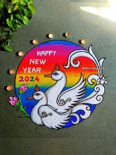 a happy new year sign painted on the side of a building with two white birds