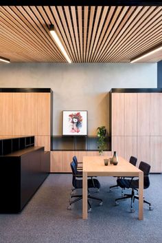 an empty conference room with black chairs and wooden paneling on the ceiling is shown