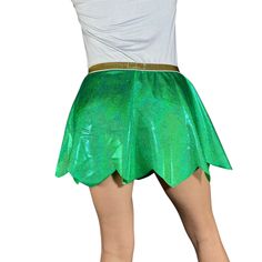 a woman in a green skirt and white shirt with her arms behind her head,