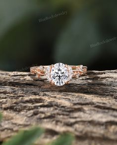 an engagement ring sitting on top of a piece of wood