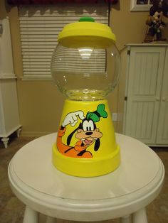 a yellow gummy machine sitting on top of a white table next to a window