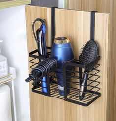 a hair dryer, combs, and other items are in a holder on the wall