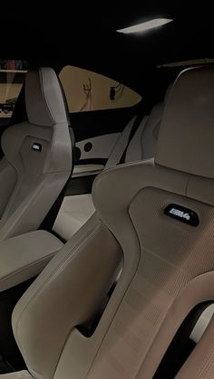 the interior of a modern car with leather and wood trims, including two seats