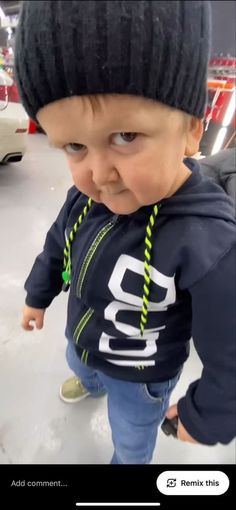 a small child wearing a black hat and blue shirt