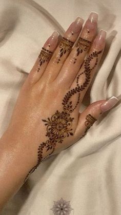 a woman's hand with henna tattoos on it