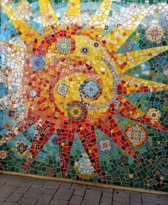 the sun is depicted in this colorful mosaic tile mural