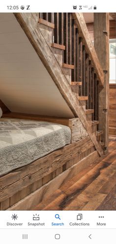 a bed sitting under a wooden banister next to a stair case in a room