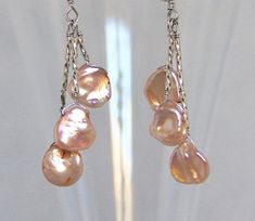 Long, elegant, shoulder duster earrings, these make a big statement. Top drilled pink freshwater pearls are wire wrapped in a staggered pattern along a sterling stem.  The dangles are strands of liquid silver beads ending in a pink Keshi pearl. The ear wires are handmade from 20 gauge sterling silver wire. The earrings are 3 1/2 inches (8.9cm) in length from the top of the ear wire.  All metal used is sterling silver.Please feel free to ask any questions and thank you for visiting! Pink Dangle Pearl Chain Jewelry, Pink Pearl Drop Chandelier Earrings, Elegant Pink Long Drop Chandelier Earrings, Elegant Pink Chandelier Earrings With Dangling Beads, Shoulder Duster Earrings, Duster Earrings, Orange Gem, Liquid Silver, Metalsmithing Jewelry