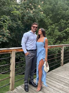 a man and woman standing on a wooden deck