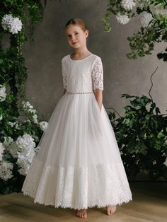 Tessa - Girl's Communion Off White Lace Tulle Dress. This graceful communion dress features a lace bodice with half sleeves and straight tulle bottom. Off-White Round neckline Half Sleeve Back zip closure Lace overlay bodice Waist crystal-trim belt Back self-tie belt Straight Tulle Skirt Lace bodice: 56% nylon/44% cotton Lace underlay layer: 100% cotton Bodice lining: 100% polyester Mesh and net skirt: 75% cotton/15% polyester/10% nylon Skirt lining: 100% cotton Hand wash Style Number: GS282 Lace Tulle Dress, Nylon Skirt, Girls Communion Dresses, Net Skirt, Skirt Lining, First Communion Dress, Crystal Belt, Baptism Dress, Crystal Trim