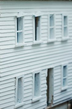 the side of a white house that is being built with siding and windows on it