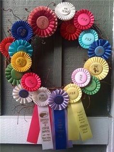 a wreath made out of colorful ribbons on the front door to celebrate someone's special day