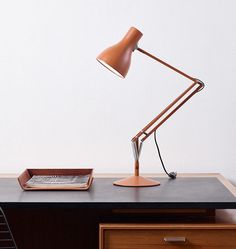 a desk lamp sitting on top of a wooden table