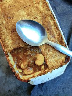 a spoon in a dish with peanut butter and sauce