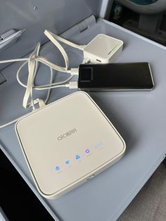 an open laptop computer sitting on top of a table next to a charger and power strip