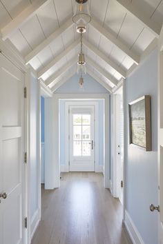 an empty hallway with white walls and wood floors