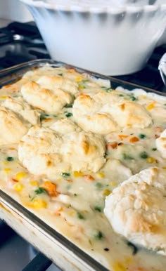 a casserole dish with biscuits and vegetables in it