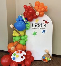 balloons and paintbrushes are on display in front of a sign