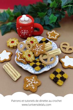 crochet christmas cookies on a plate next to a cup and potted plant