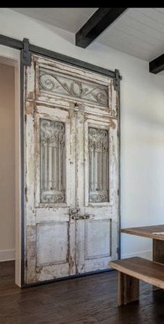 an old door is open on the inside of a room with wood floors and white walls