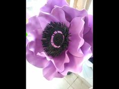 a large purple flower sitting on top of a table