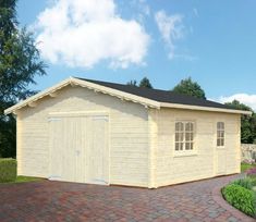 a small wooden garage with a brick driveway