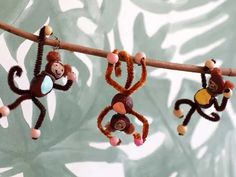 three monkeys hanging from a branch with beads