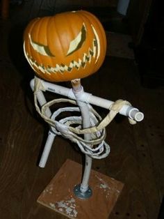 a pumpkin sitting on top of a wooden table next to an electrical cord and plugged in