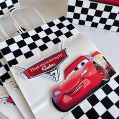 cars birthday party favors with black and white checkered table cloth, red lightning car