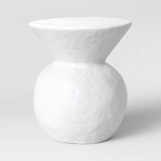 a white vase sitting on top of a table