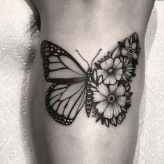 a black and white photo of a butterfly with flowers on it's side ribcage