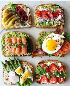 toasted sandwiches topped with fresh fruits and vegetables are arranged in the shape of an egg