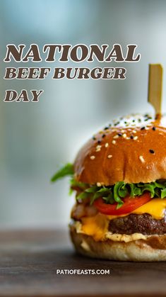 a hamburger with lettuce, tomato and cheese on it sitting on a wooden table