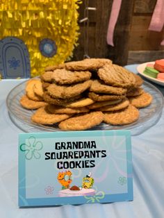 there is a plate of cookies on the table next to a sign that says grandma's squarepants cookies