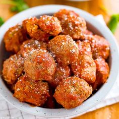 a white bowl filled with meatballs covered in marinara sauce