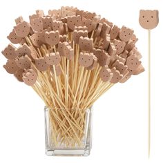 a bunch of sticks that have some brown bears on them in a glass vase with toothpicks sticking out of it