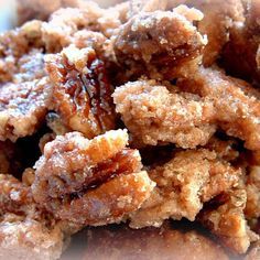 a pile of pecans sitting on top of a white plate with powdered sugar