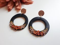 Large circle, Elegant fall earrings with florals These are unique, handmade, polymer clay, floral earrings. Perfect earrings for your fall outfit. Length: 1.96in  Drop Length: 1.57in. Colors: Orange, Beige Florals Background: Black with Rose Gold post. The method is known as 'appliqued technique'. Using tiny pieces of clays and a sharp needle. I don't use molds to prepare my jewelry.  Each small parts of the motifs are made by hand and placed one by one on the background with a needle. It is a v Handmade Polymer Clay Circle Earrings, Handmade Polymer Clay Round Hoop Earrings, Floral Circle, Clay Keychain, Polymer Earrings, Polymer Clay Jewelry Diy, Elegant Fall, Colors Orange, Clay Jewelry Diy