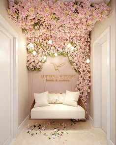 a white couch sitting under a pink flower covered wall