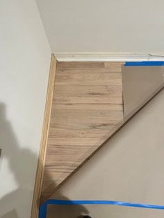 a man is painting the walls in his room with blue tape and a paint roller