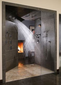 a shower with water coming out of it in a bathroom next to a fire place