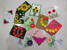 several cards with flowers on them sitting on a table next to each other and the words happy birthday written in different languages